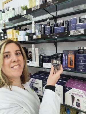 Mujer mostrando productos de cosmética en estantería - Betifarma